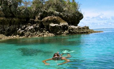 Traveller swimming at the blue waters during a budget beach trip