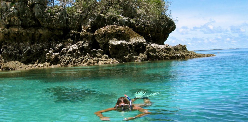 Traveller swimming at the blue waters during a budget beach trip