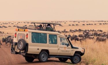 A tour van overlooking the mara with it safari hatch open